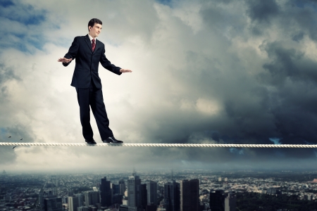 Image of pretty businessman balancing on ropeの写真素材