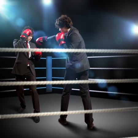 Two young businessman boxing againts dark background   conceptual collageの写真素材