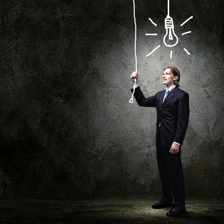 Image of businessman in black suit against dark background