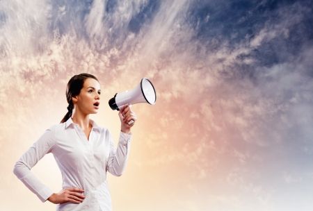 Image of young businesswoman screaming in megaphoneの写真素材