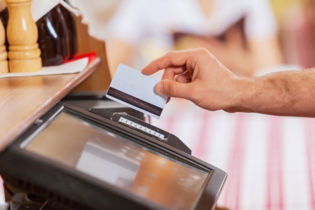 Close-up image of cashier male hands holding cardの写真素材