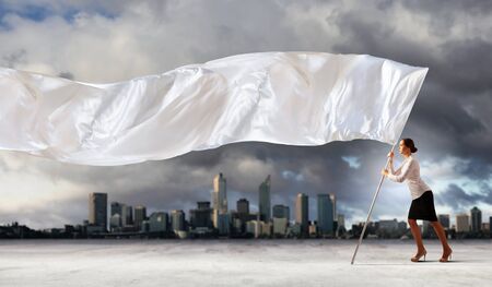 Image of attractive businesswoman holding white flag  Place for textの写真素材