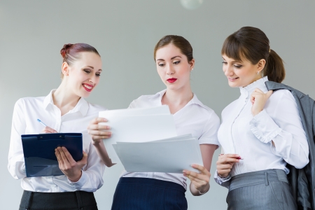 Image of attractive businesswomen holding folders and discussingの写真素材