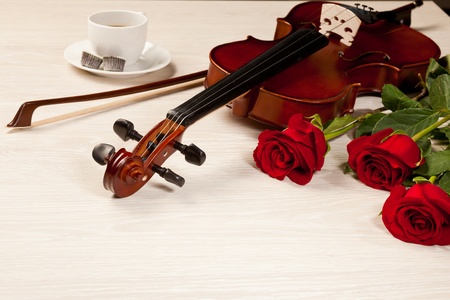 Red roses and a violin on the tableの写真素材