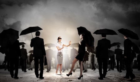 Image of businesswoman in blindfold walking among group of peopleの写真素材