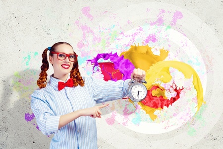 Young woman with an old-fashioned alarm clockの写真素材