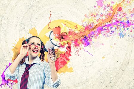 Funny looking woman speaking with a megaphoneの写真素材