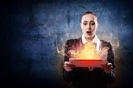 Image of astonished business woman holding a tabletの写真素材