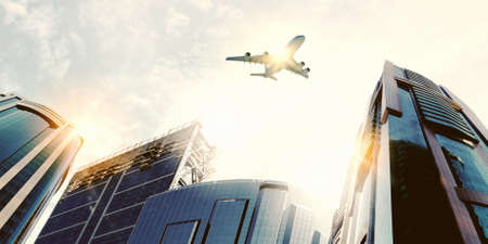 Plane flying above skyscrapers  Business travel conceptの写真素材