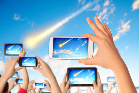 Close up of human hands taking photo of falling meteorite