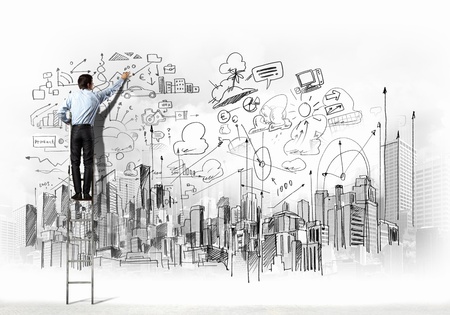 Back view of businessman drawing sketch on wallの写真素材