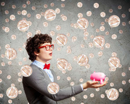 Image of young businessman in red glasses holding moneyboxの写真素材