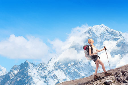 Pretty young woman tourist standing on top of mountain