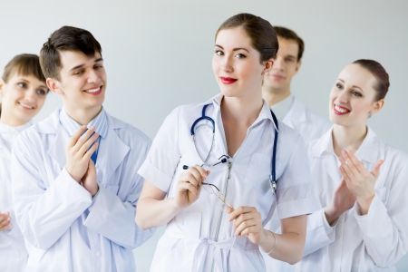 Attractive female doctor in uniform congratulated by colleaguesの写真素材