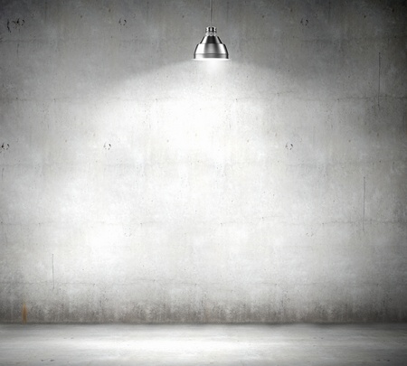 Stone blank wall illuminated with hanging above lamp  Place for textの写真素材