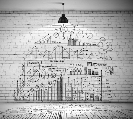 Drawn business plan on wall illuminated by lamp aboveの写真素材