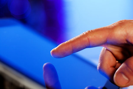 Close-up image of finger touching blue screenの写真素材