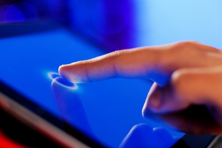 Close-up image of finger touching blue screenの写真素材