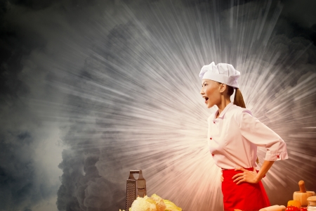 Asian female cook in anger against color background with shine effectsの写真素材