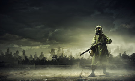 Man in gas mask and camouflage holding gun  Disaster concept