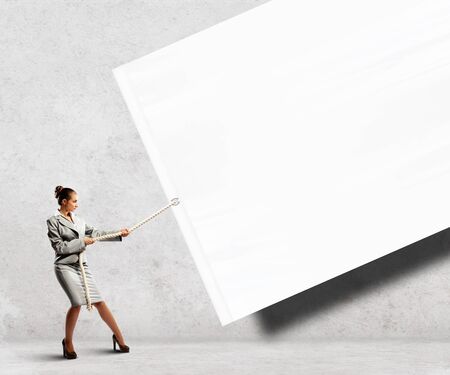 Image of businesswoman pulling blank banner  Place for textの写真素材