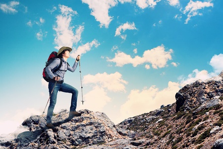Image of young man mountaineer standing atop of rockの写真素材