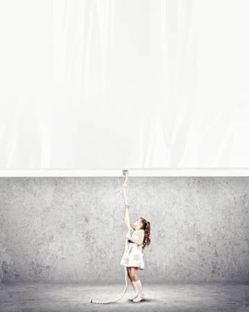 Little pretty girl pulling blank banner  Place for textの写真素材