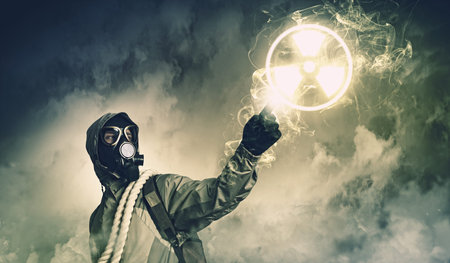 Man in respirator against nuclear background touching symbol  Pollution conceptの写真素材