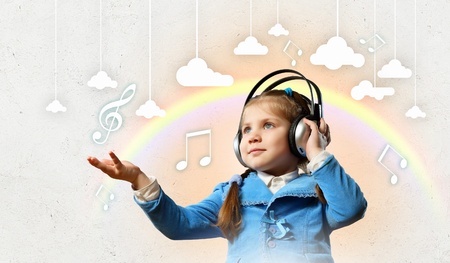 Little cute girl in headphones enjoying musicの写真素材