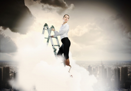 Image of young ambitious businesswoman climbing ladder  Promotion conceptの写真素材