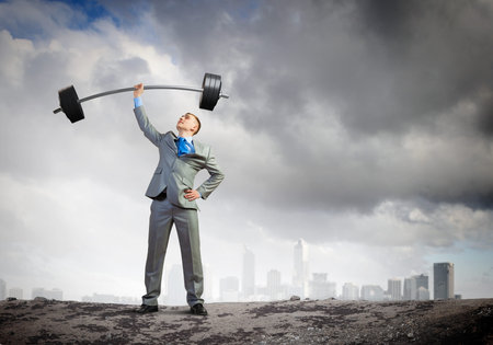 Image of strong businessman lifting barbell above head with one handの写真素材