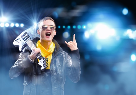 Young man, rock musician in jacket with guitarの写真素材