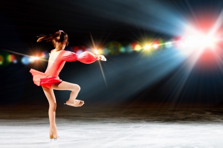 Little girl figure skating at sports arenaの写真素材