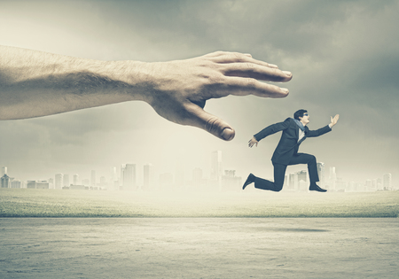 Big human hand catching businessman  Professional relationsの写真素材