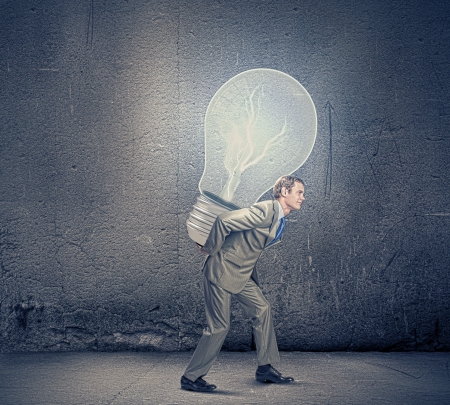 Image of businessman carrying bulb on back  New ideaの写真素材