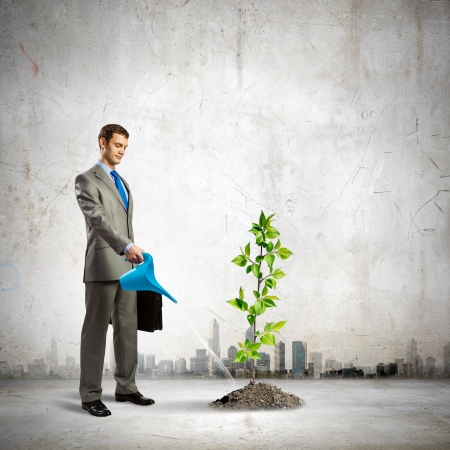 Image of businessman watering sprout with canの写真素材