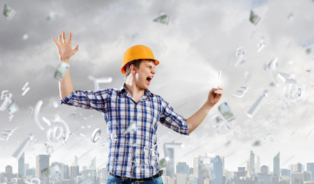 Image of young man engineer screaming angrily in mobile phone