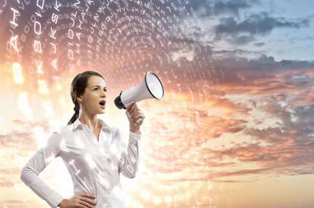 Image of young businesswoman screaming in megaphoneの写真素材