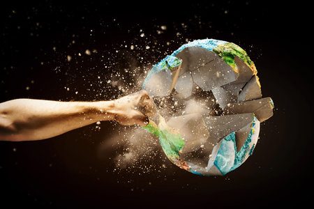 Close up image of human hand breaking earth planet