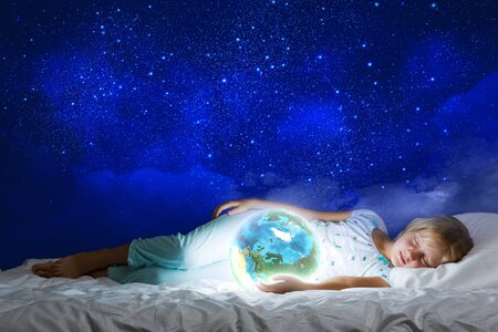Girl in bed with Earth planet in hands  Elements of this image are furnished by NASAの写真素材