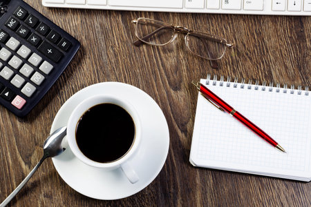 Business work place with cup of coffee calculator and glasses
