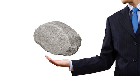 Businessman in suit huge holding stone in palmの写真素材