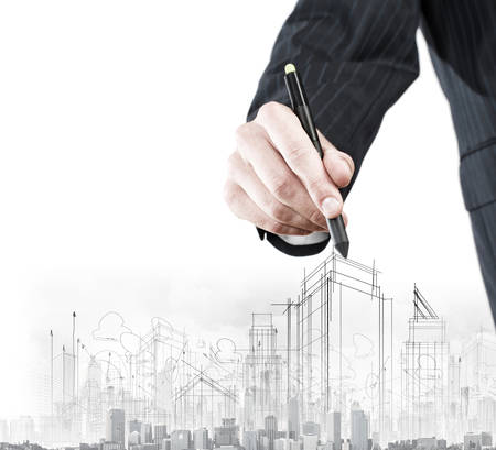 Close up of businessman hand drawing sketches of buildingsの写真素材