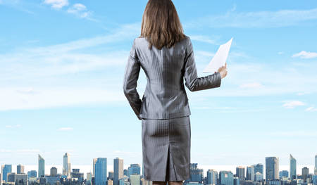 Back view of businesswoman holding papers in handsの写真素材