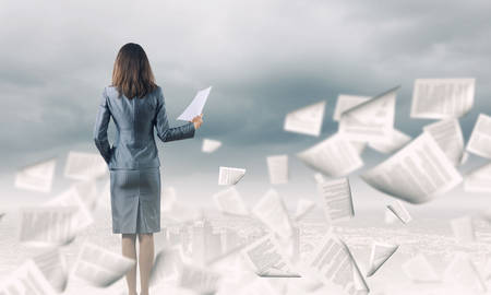 Back view of businesswoman holding papers in handsの写真素材