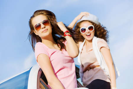 Young pretty women leaning out of car windowの写真素材