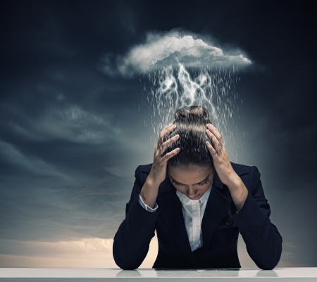 Young crying businesswoman with hands on headの写真素材
