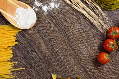 Cherry tomatoes and vegetables on kitchen tableの写真素材