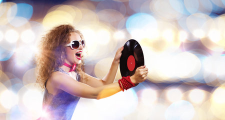 Young pretty girl dj at disco party holding vinyl