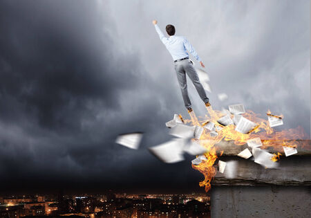 Rear view of businessman superhero flying up in skyの写真素材